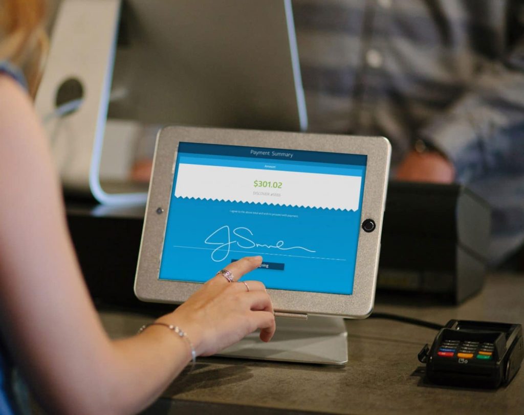 Customer confirming their signature on an iPad using ServiceCentral's retail solutions