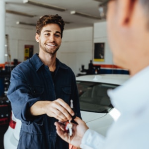 Automotive mechanic handing keys back to customer