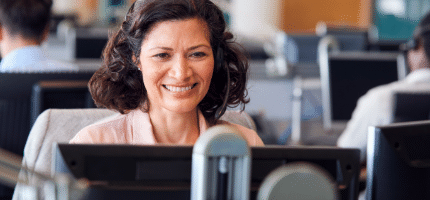 woman happily working on after-sales services on her desktop